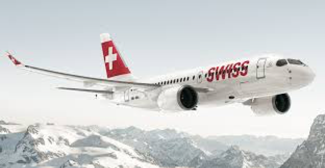 It's a red and white swiss air 747 airplane flying over white capped mountain peaks from Zurich to Dar es Salaam travel itinerary cheese chocolate