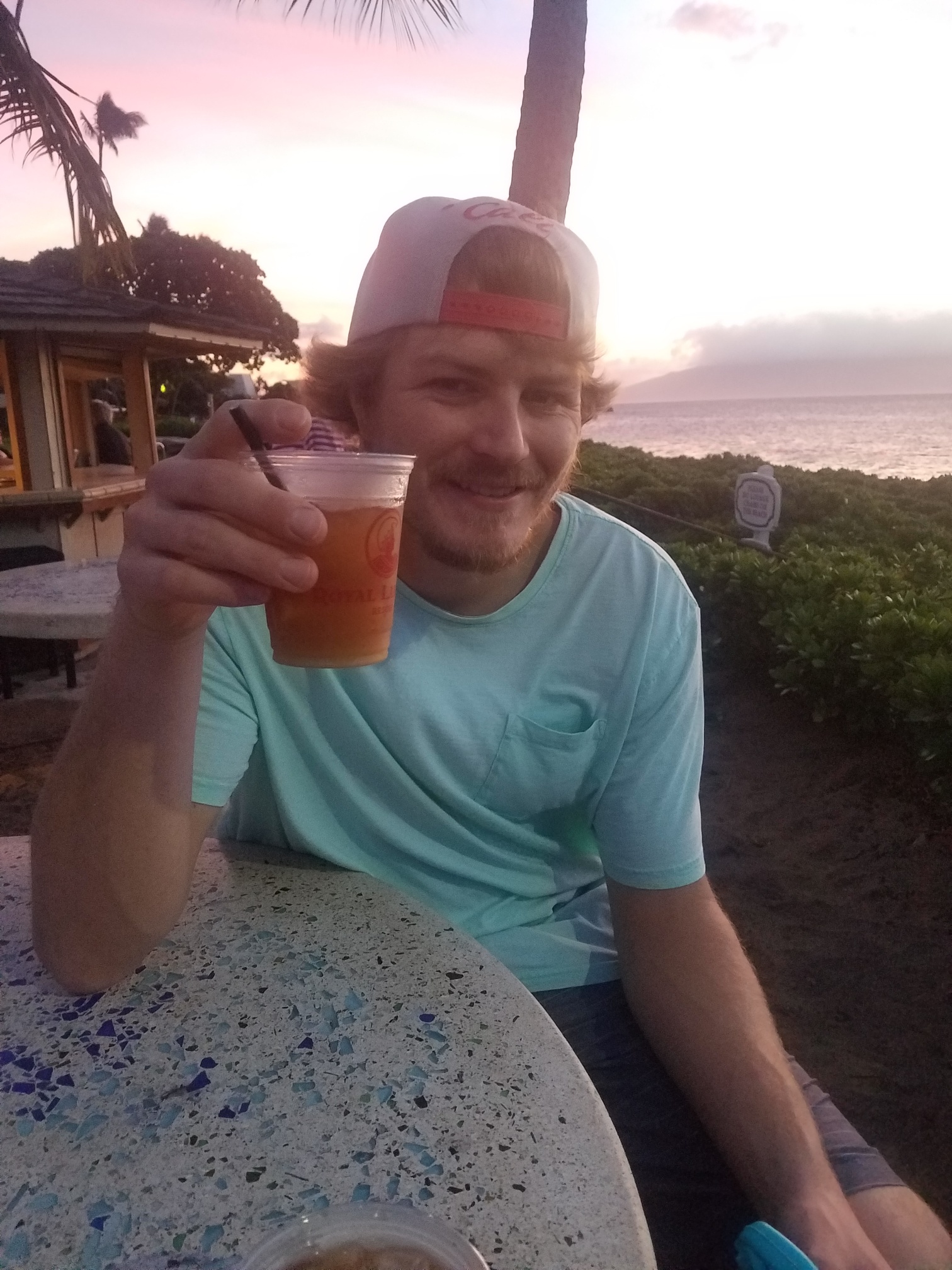 Man with hat and drink on beach